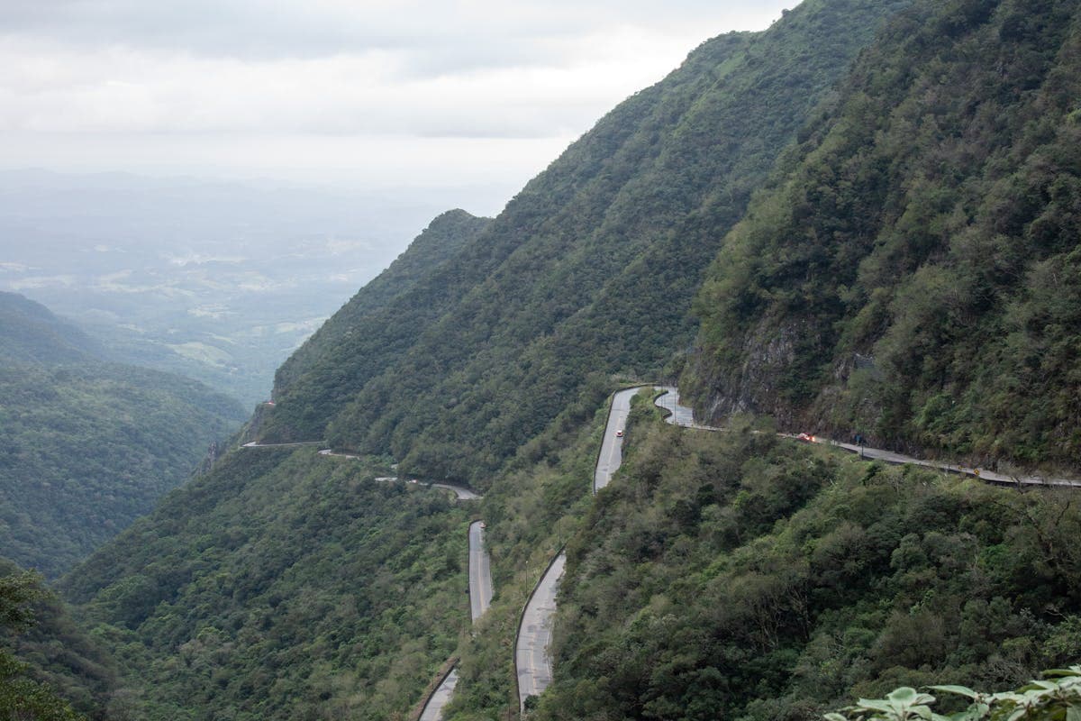 Cyclists climbing the 284 curves of Serra do Rio do Rastro with dramatic mountain views in Santa Catarina