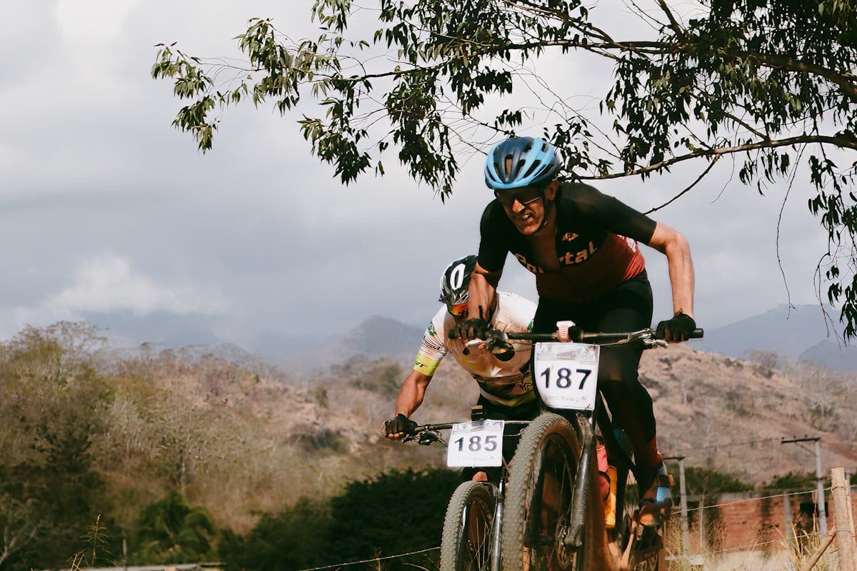 Mountain bikers navigating rocky trails through the historic mining landscape of Mariana in Minas Gerais during Iron Biker